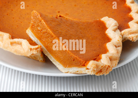 GESAMTE KÜRBISKUCHEN MIT GESCHNITTENEN SCHEIBE Stockfoto