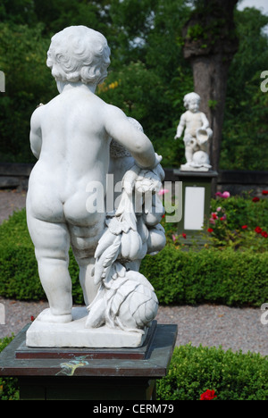 Weißen Marmorstatuen von Amor im Rosengarten Stockfoto