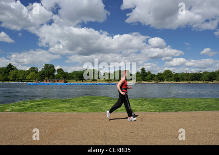 Eine Frau, vorbei an der Serpentine im Hyde Park joggen. Stockfoto