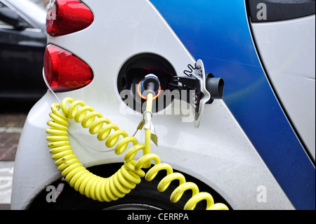 Ein Elektroauto lädt Batterien beim Parken an einer Ladestation in Amsterdam, Niederlande. Stockfoto