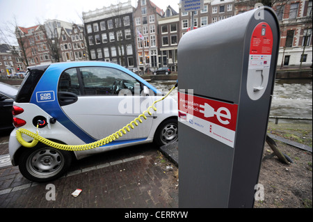 Ein Elektroauto lädt Batterien beim Parken an einer Ladestation in Amsterdam, Niederlande. Stockfoto