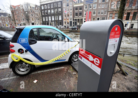 Ein Elektroauto lädt Batterien beim Parken an einer Ladestation in Amsterdam, Niederlande. Stockfoto