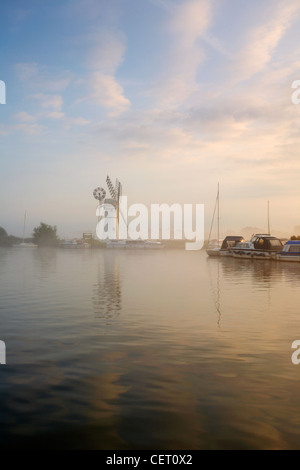 Eine neblige Sicht über das Wasser zu Thurne Mill bei Sonnenaufgang. Stockfoto