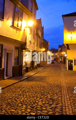 Elm Hill, gepflasterten eine historische Gasse mit vielen Bauten aus der Tudor-Zeit, in der Dämmerung beleuchtet. Stockfoto