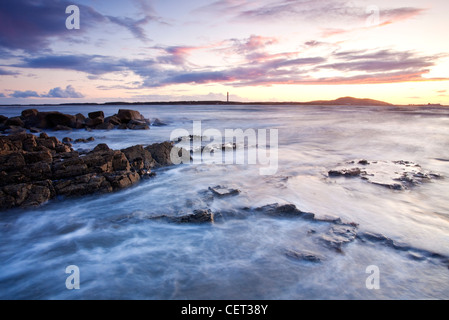 Sonnenuntergang mit Blick auf Holyhead Mountain angesehen von Porth Penrhyn-Mawr auf die Isle of Anglesey. Stockfoto