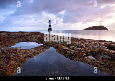 Ein Blick auf Penmon Leuchtturm und Puffin Island in der Morgendämmerung auf der Küste von Anglesey in Nord-Wales. Stockfoto