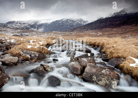 Wasser fließt nach unten von Bergen über Felsen in Snowdonia-Nationalpark im Winter. Stockfoto