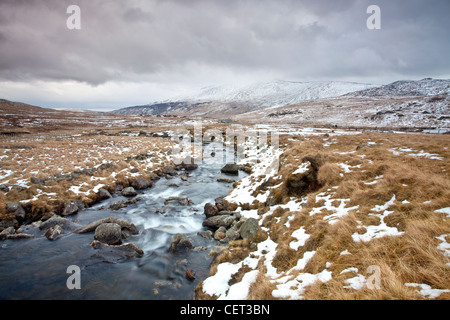 Wasser fließt nach unten von Bergen über Felsen in Snowdonia-Nationalpark im Winter. Stockfoto