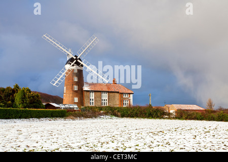 Schnee bedeckt den Boden durch Weybourne Windmühle, ein Klasse-ll aufgeführten Gebäude aus dem Jahr 1850. Stockfoto