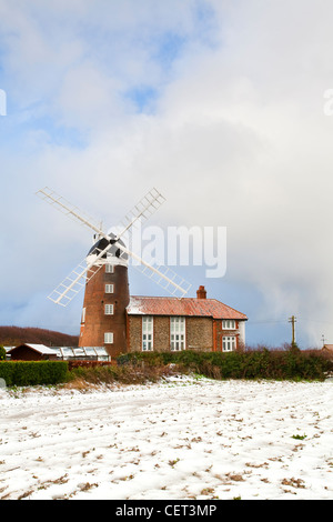 Schnee bedeckt den Boden durch Weybourne Windmühle, ein Klasse-ll aufgeführten Gebäude aus dem Jahr 1850. Stockfoto