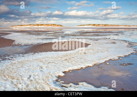 Schnee am Strand aus der Flut an Wells-Next-the-Sea an der Nordküste Norfolk verließ. Stockfoto