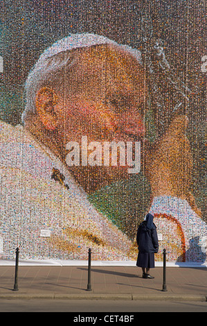 eine Nonne, Blick auf eine riesige Collage von Papst Johannes Paul II, Krakow (Krakau), Polen Stockfoto