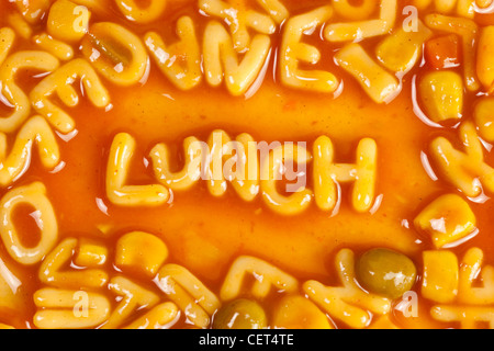 Alphabet geformten Nudeln bilden das Wort Mittagessen in Tomatensauce Stockfoto