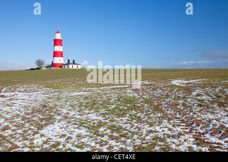 Winter Schnee in einem Feld von Happisburgh Leuchtturm, der älteste funktionierende Leuchtturm in East Anglia. Stockfoto