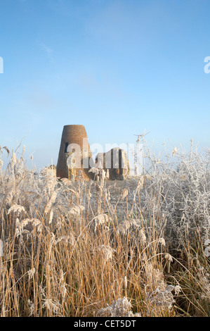 Die Windmühle und Torhaus von St Benets Abbey auf den Norfolk Broads, umgeben von gefrorenen Sumpf Land und Schilf nach einer alle Stockfoto