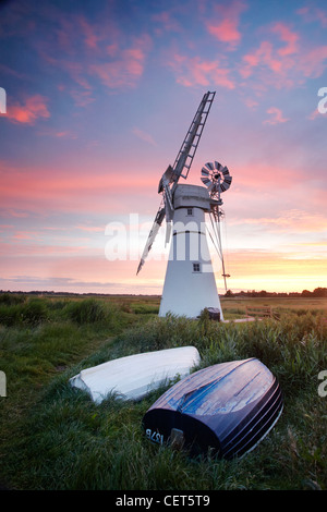 Sonnenaufgang über dem umgedrehten Boote von Thurne Mill stehen am Eingang zum Thurne Dyke auf den Norfolk Broads. Stockfoto