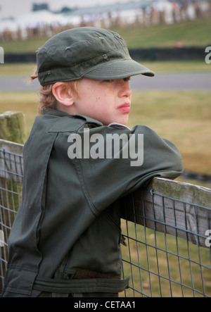 Junge in Overall beobachten Autorennen beim Goodwood Revival. Stockfoto