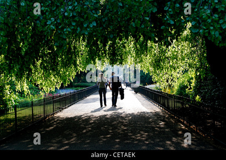 Ein paar, ein Spaziergang entlang eines Pfades durch Kensington Gardens. Stockfoto