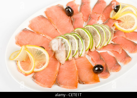 In Scheiben geschnittene Chum Lachs und Makrele Closeup dekoriert mit Limetten, Zitronen und Oliven Stockfoto