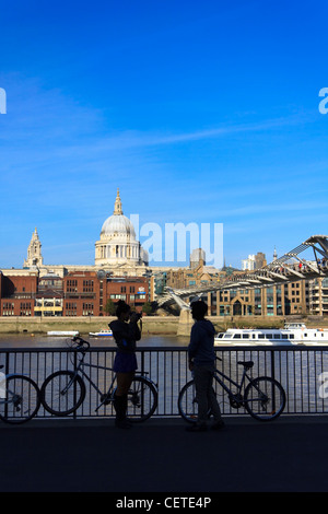 Ein junges Paar fotografieren über den Fluss Themse vor St. Paul Kathedrale in London, Vereinigtes Königreich. Stockfoto