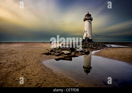 Ein Passant durch neben Talacre Leuchtturm am Strand entlang spazieren. Stockfoto