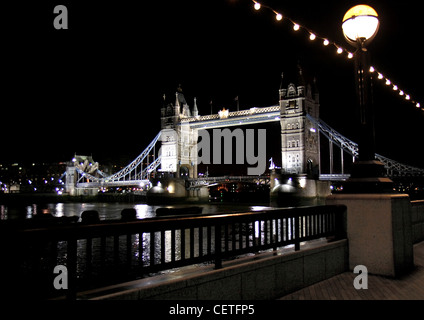 Ein Blick über die Themse eine beleuchtete Tower Bridge bei Nacht. Stockfoto