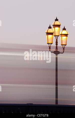 Straßenlaterne auf Battersea Brücke mit unscharfen Bus. Erbaut 1886, hat die aus Eisen und Stahl Freischwinger Brücke fünf segmenta Stockfoto