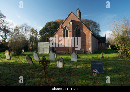 Der seltsame kleine rote Ziegel Mariä Himmelfahrt und der Friedhof, in Dorset Dorf von Waldgebieten. England, United Kingdom. Stockfoto