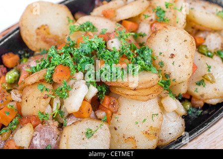 Gebratene Kartoffel mit Fleisch und Gemüse auf einem weißen Stockfoto