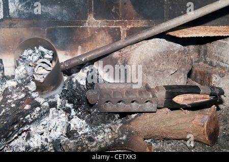 Schmelzendes Blei, um selbstgemachte Sinker zum Angeln herzustellen. Geschmolzenes Metall wird aus einer Pfanne in eine quadratische Gussform in einer Metallwerkstatt gegossen. Stockfoto