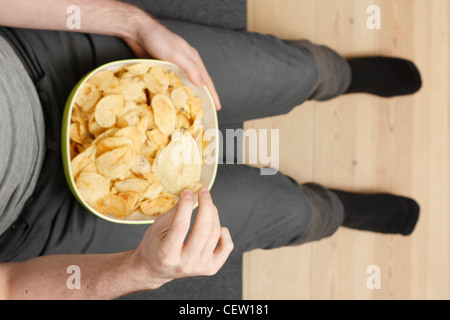 Ein Mann auf einer Couch Potato Chips Essen Stockfoto