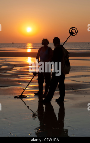 Metall-Detektoren an einem Strand bei Sonnenaufgang in der silhouette Stockfoto