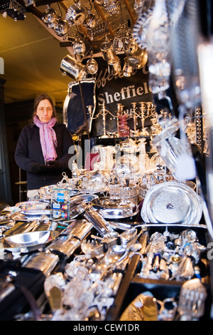 Portobello Road Market Street London, gelangweilt im mittleren Alter Dame Anbieter von antiken Collectible silbernen Kerzenständern Geschirr shop Abschaltdruck Stockfoto