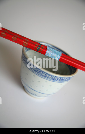 Roten hölzerne Stäbchen ruhen in ganz China Tasse Stockfoto