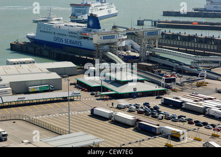 LKW und PKW warten auf eine Fähre in der geschäftigen Hafen von Dover, Kent, während eine andere Fähre Kanten seinen Weg in einen Liegeplatz zu laden. Stockfoto