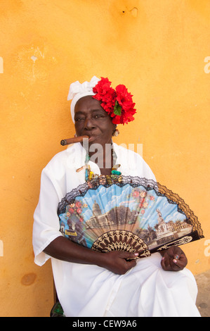 Kubanische Frau trägt eine Santeria weißen Kleid eine große Zigarre rauchend, Havanna, Kuba Stockfoto