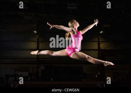 Weiblicher Gymnast springen in Luft Stockfoto