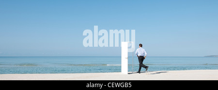 Mann läuft auf Strand in Richtung Tür, Rückansicht Stockfoto