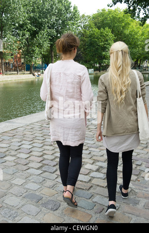 Junge Frauen gehen zusammen, Rückansicht Stockfoto