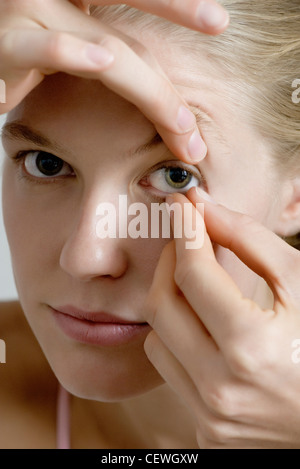 Junge Frau in Kontaktlinsen setzen Stockfoto