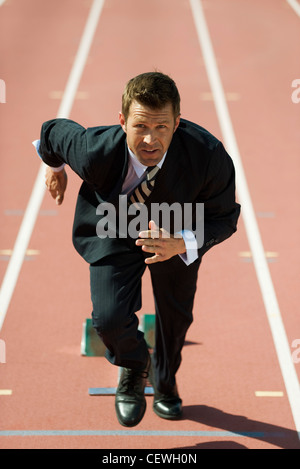 Geschäftsmann an der Startlinie auf Laufband Stockfoto