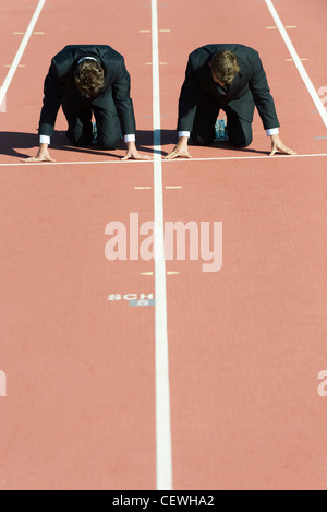 Geschäftsleute kauerte in Startposition auf Laufband Stockfoto