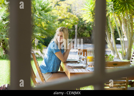 Frau sitzt am Tisch, über die Schulter blicken Stockfoto