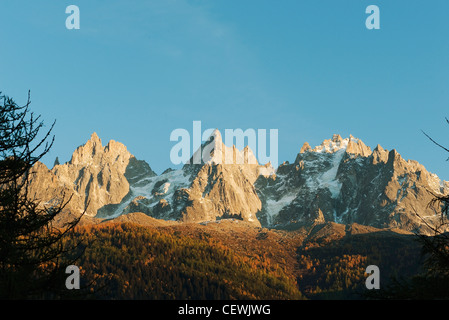 Schneebedeckte Berge und Wald in herbstlichen Farben Stockfoto