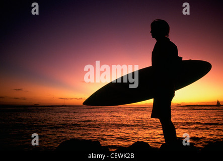 Hinterleuchtete Surfer steht Meer mit Vollpension, Hawaii, USA Stockfoto