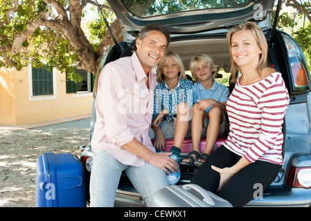 Familie Zusammensitzen auf der Rückseite Autos mit Fließheck öffnen Stockfoto