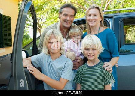 Familie posiert neben Auto, Porträt Stockfoto