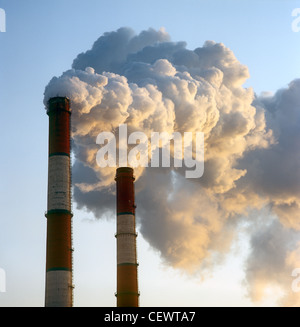 Luftverschmutzung durch Rauch aus zwei Fabrikschornsteine. Stockfoto