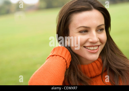 Frauen tragen orange Rollkragen Pullover mit Hand Nacken Stockfoto