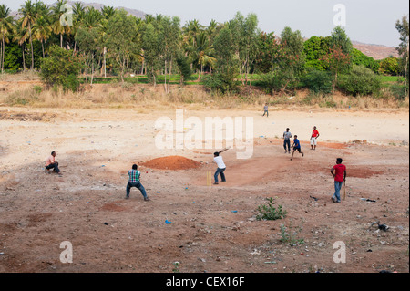 Indischen jungen Fussball auf einem ausgetrockneten Flussbett in der ländlichen indischen Stadt von Puttaparthi, Andhra Pradesh, Indien Stockfoto